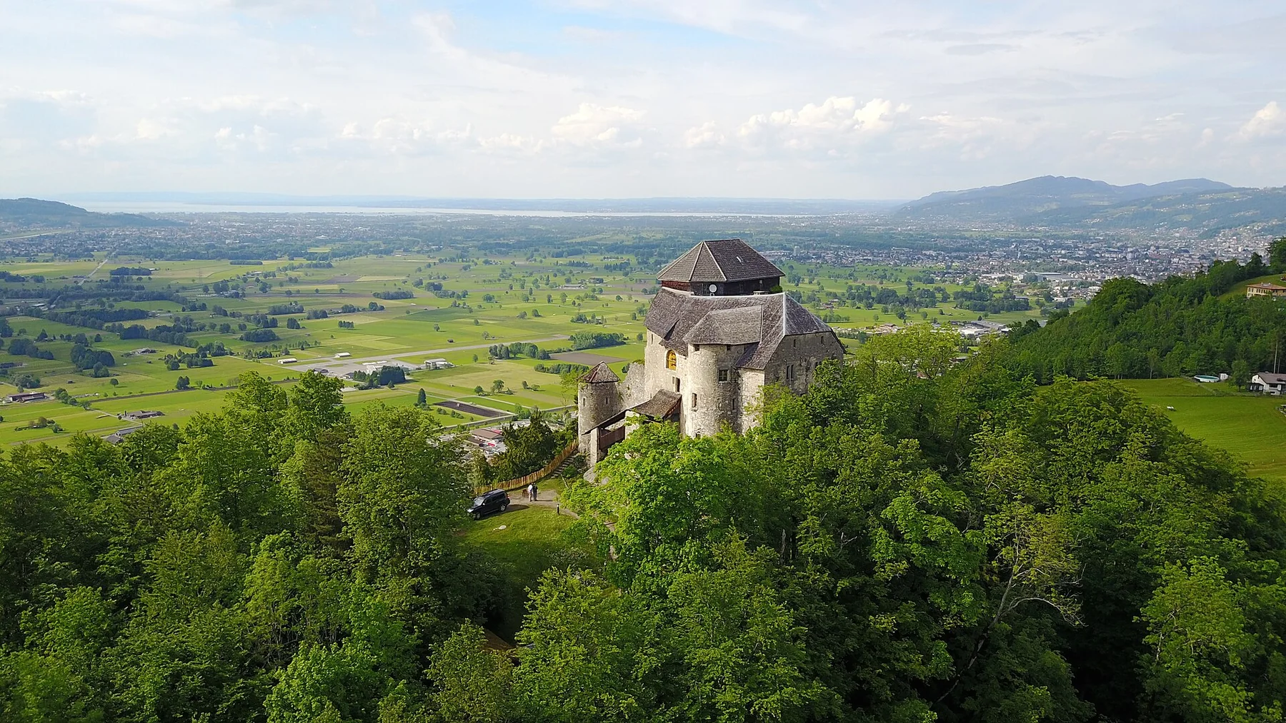 Luftbild von Burg Neu-Ems, Schloss Glopper, über dem Rheintal mit Bodensee am Horizont