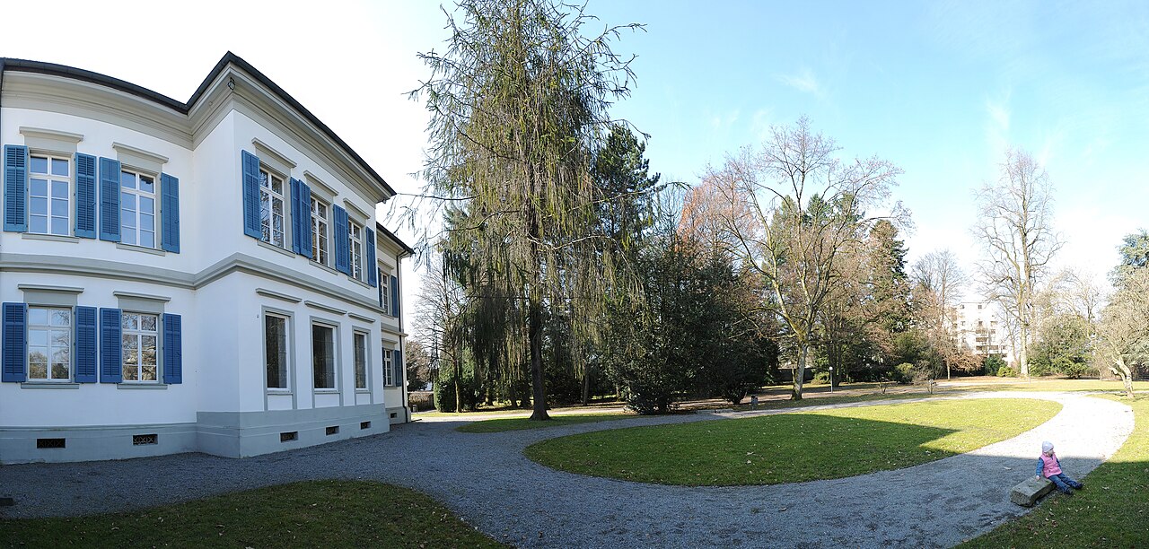 Helles Palais Thurn und Taxis mit grüner Parkanlage und geschwungenem Weg in Bregenz