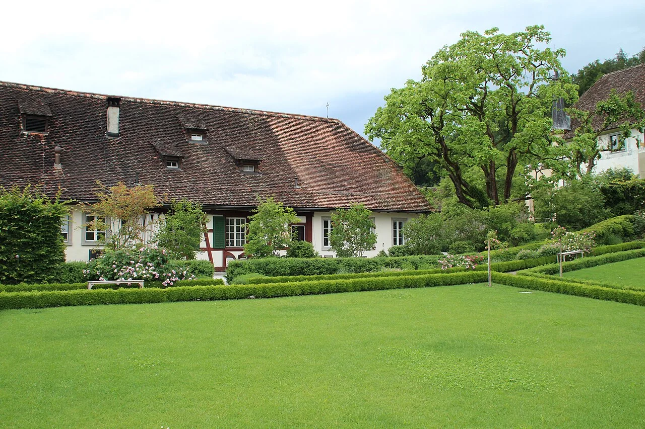 Grüner Garten mit historischem Gebäude an der Kartause Ittingen