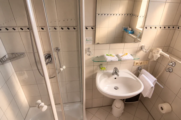 Bad mit Waschtisch und Haartrockner im Hotel Lindenallee