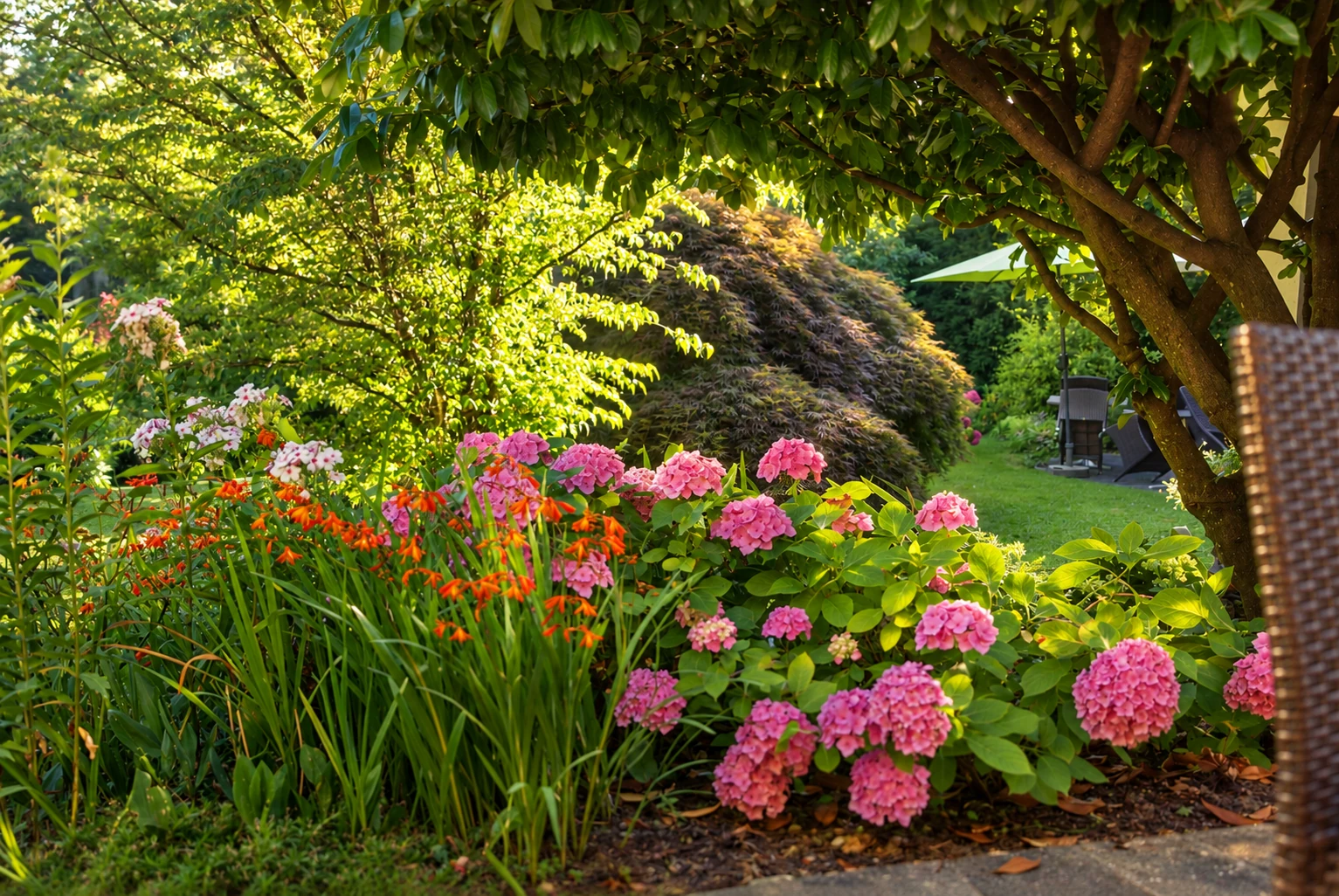 Blumen und geschützte Sitzplätze im Hotelgarten