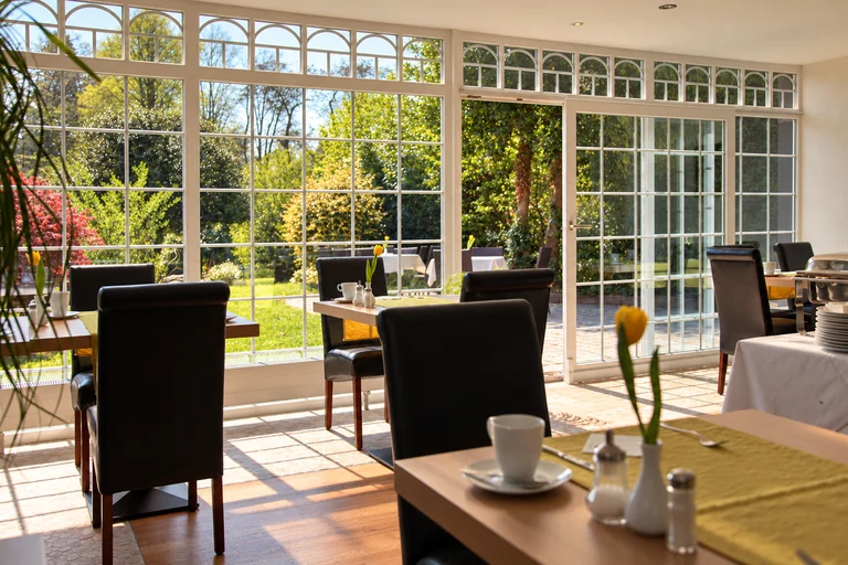 Frühstücksplätze mit Gartenblick im Hotel Lindenallee