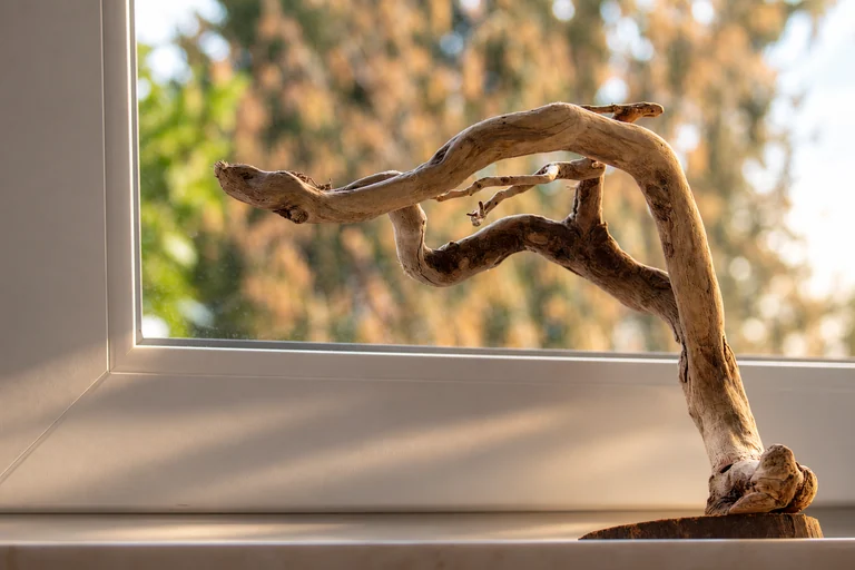 Holzskulptur am Fenster im Hotel Lindenallee