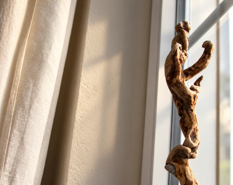 Holzskulptur im Fensterlicht im Hotel Lindenallee