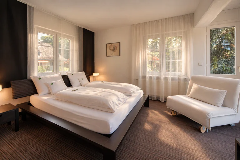 Suite mit weißem Sessel im Hotel Lindenallee
